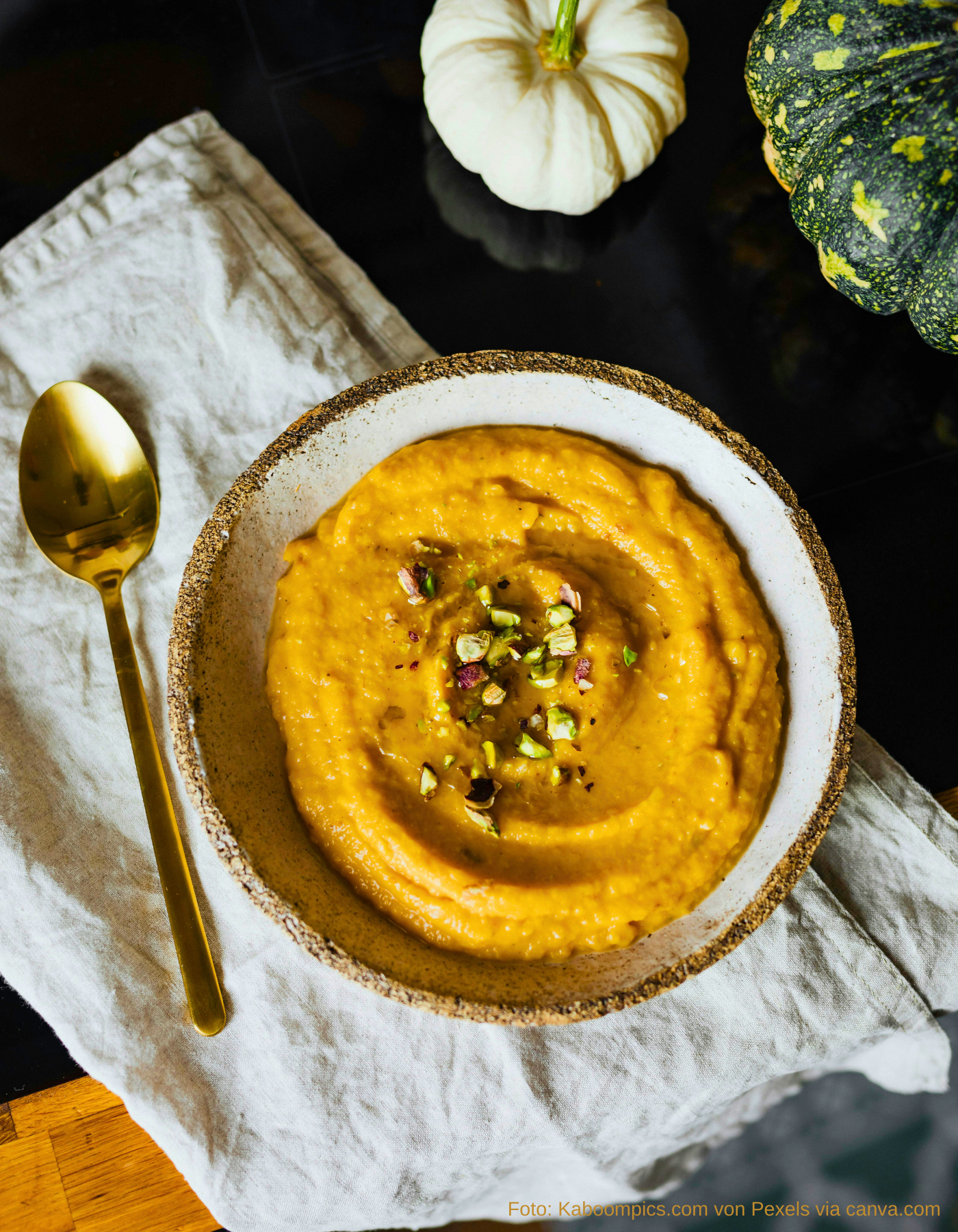 Vegane Kürbissuppe serviert mit knusprigem Baguette