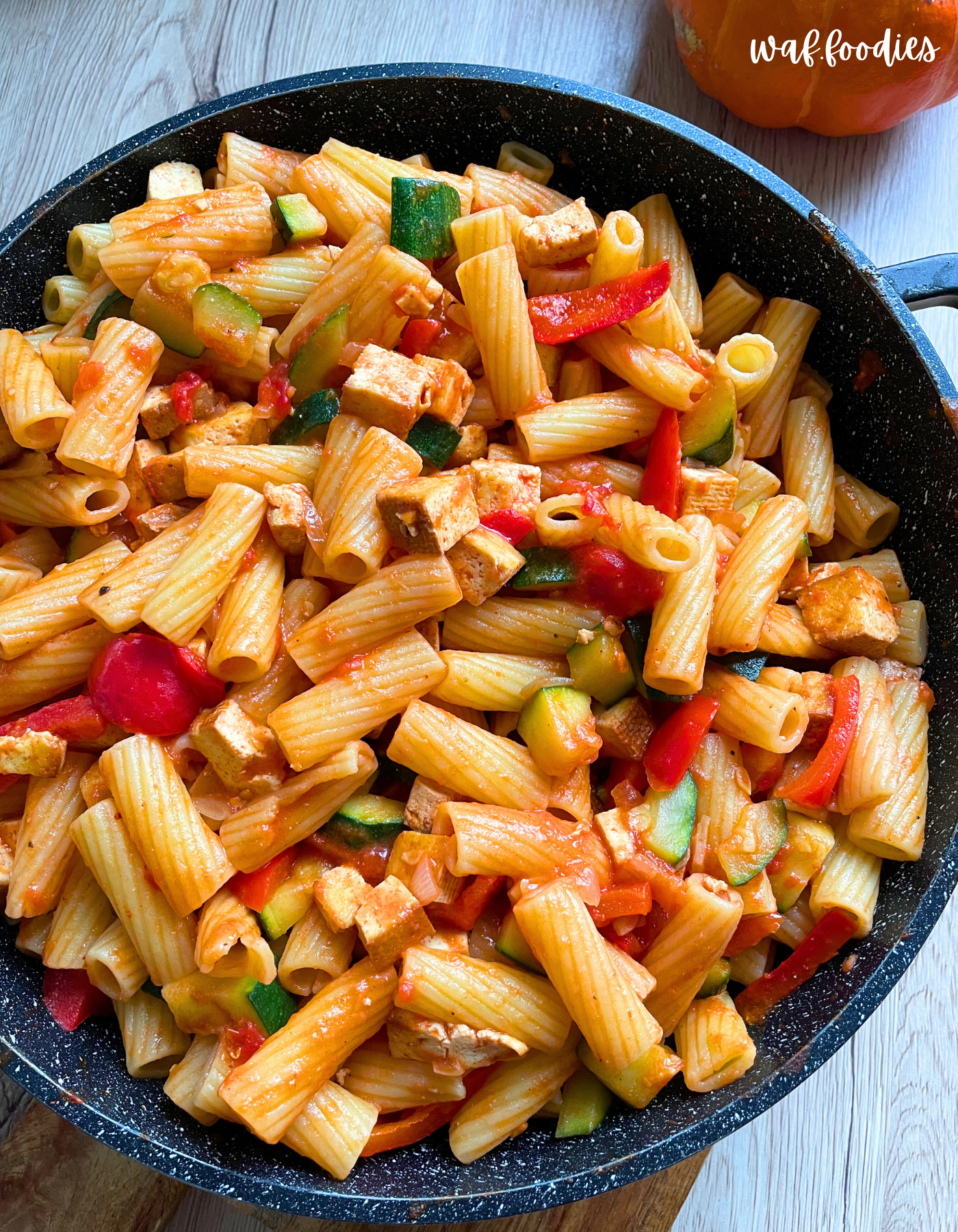 Nudelpfanne mit Tofu und frischem Gemüse in fruchtiger Tomatensauce serviert