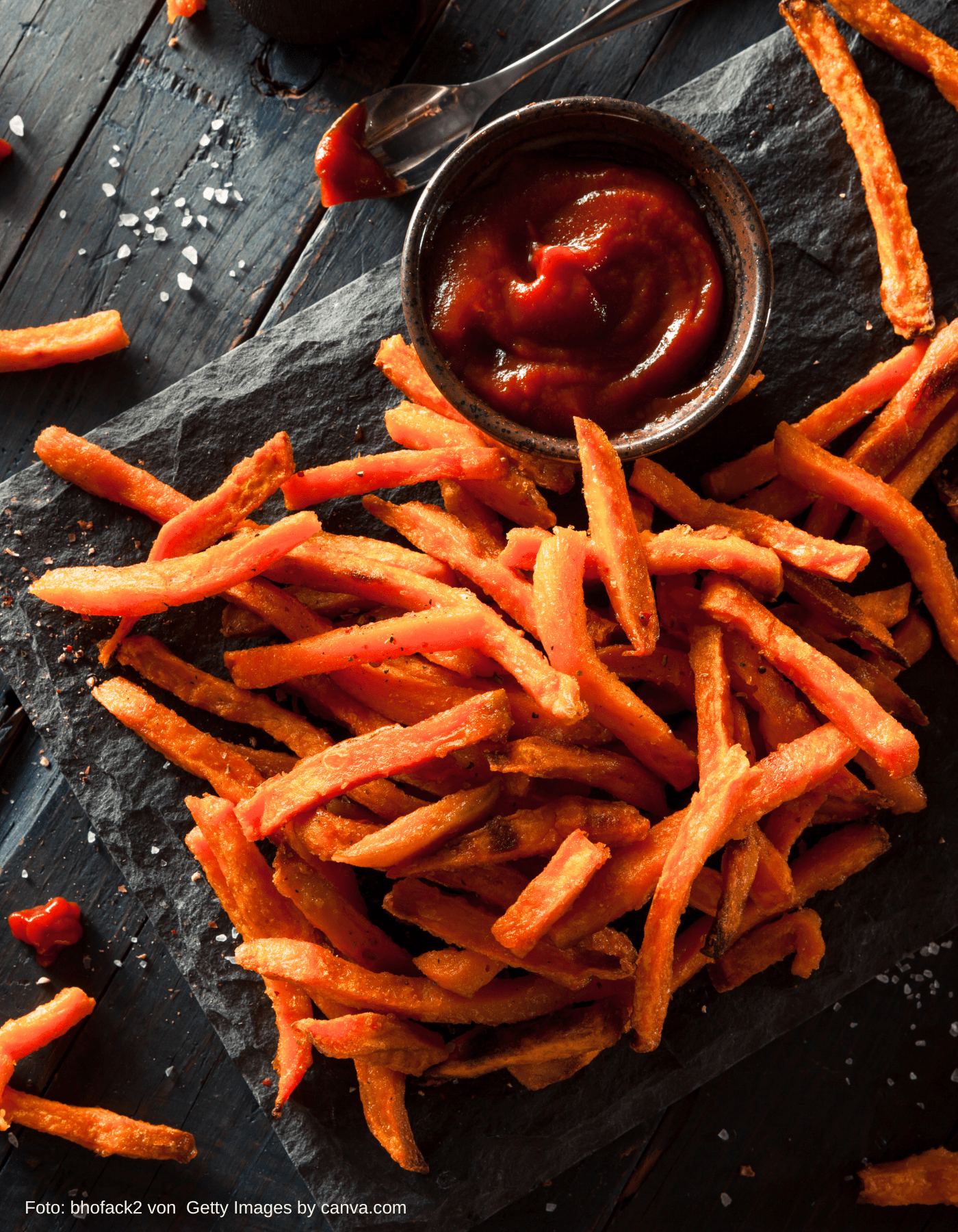 Knusprige vegane Süßkartoffelpommes frisch aus der Fritteuse auf einem Teller