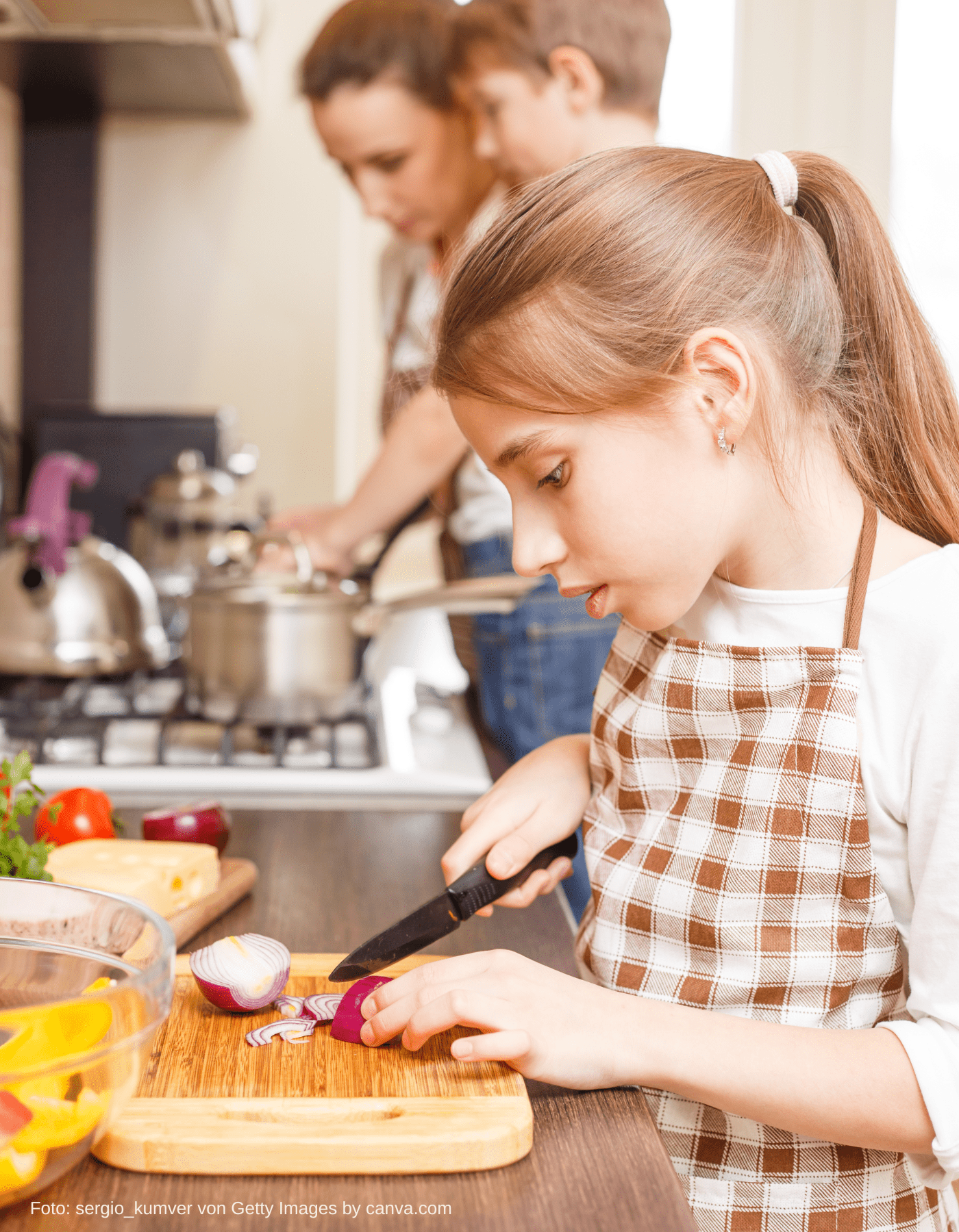 Kind benutzt Kindermesser, um Karotten in der veganen Familienküche zu schneiden